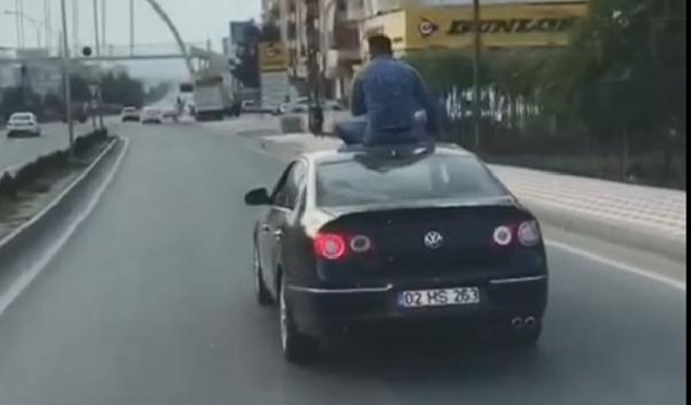 Seyir halindeki otomobilin üzerine oturdu...