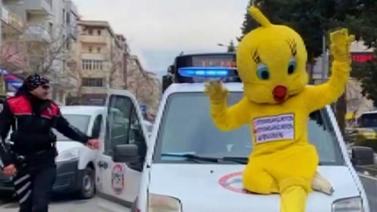 Civciv kıyafetiyle trafikte polis aracına oturan vatandaş kafese kondu