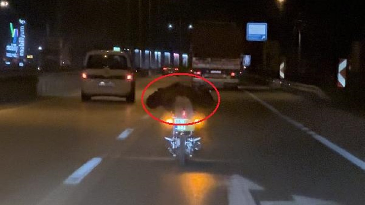 Plakasını bezle kapattı! Motosikletinin üzerine yüzüstü yatarak trafikte yolculuk yaptı