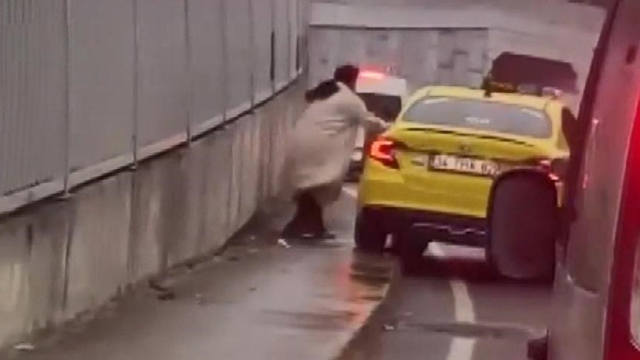 Kaldırıma çıkan taksiye sinirlenen kadın aracı yumrukladı