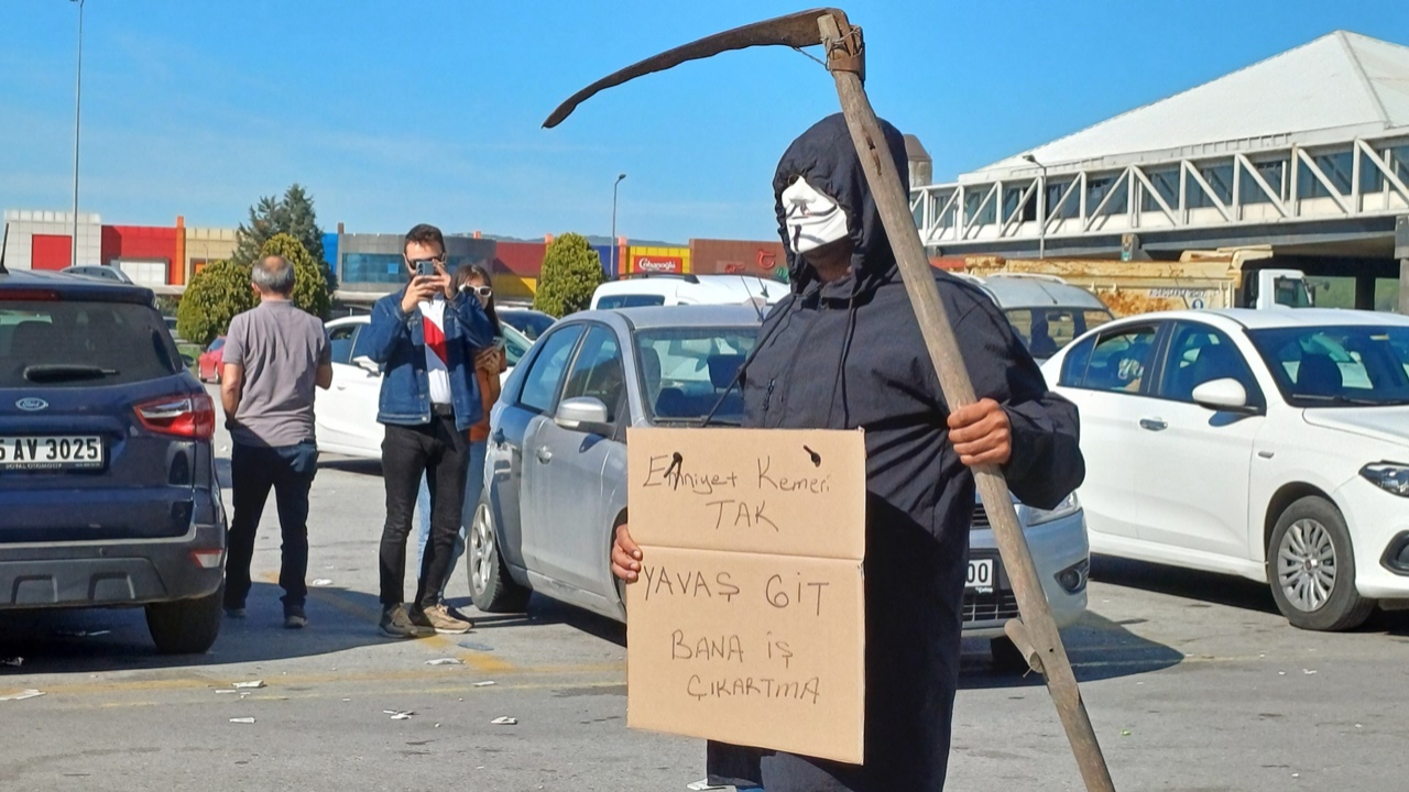 Düzce'de trafikte ilginç olay! Bir vatandaş yüzünde maske elinde tırpanla bayram tatiline çıkan sürücüleri uyardı