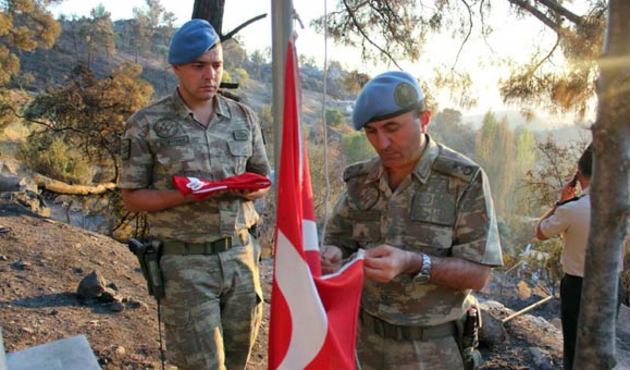 Köy yandı, şehit mezarlığındaki Türk bayrağı yanmadı!