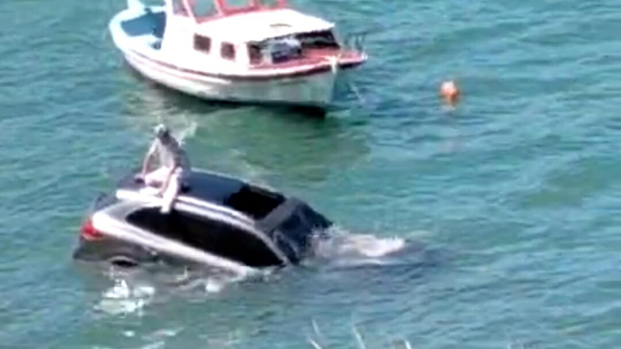 Ayvalık'ta ilginç kaza... Otomobiliyle denize uçan adam aracının üzerine oturup yardım bekledi