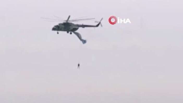 Askeri helikoptere takılan paraşütçü asılı kaldı