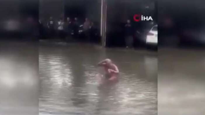 Antalya'da bir vatandaş şiddetli yağış nedeniyle göle dönen caddede banyo yaptı